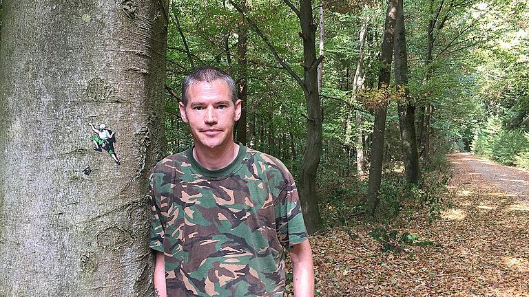 Der Graffit-Künstler JPS, Jamie Paul Scanlon &ndash; und eines seiner Werke im Steinfelder Wald.