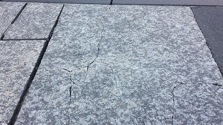 Gebrochene Granitplatte &ndash; tief ausgebröselte Fugen.