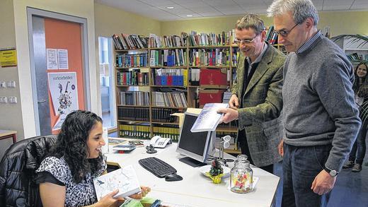 Spaß bei der Arbeit: Mandy Hassan leiht den beiden Lehrern Ulrich Bäumler und Rudolf Baumgarten Bücher aus.