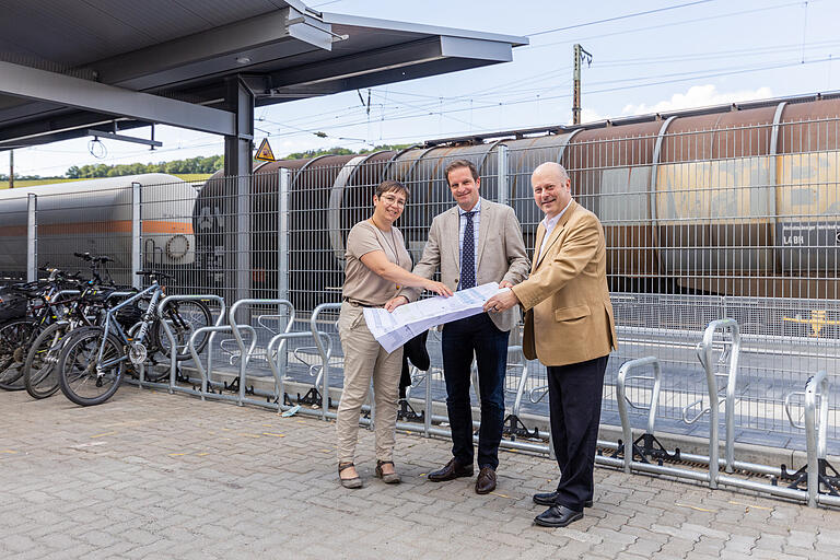 Annette Messerer (Fachbereichsleiterin Tiefbau &amp; Verkehrswesen), Benjamin Schneider (Baureferent Stadt Würzburg) und Elmar Hirsch (Leiter Bahnhofsmanagement Würzburg) erklären am Gleis 1 die weiteren Pläne.