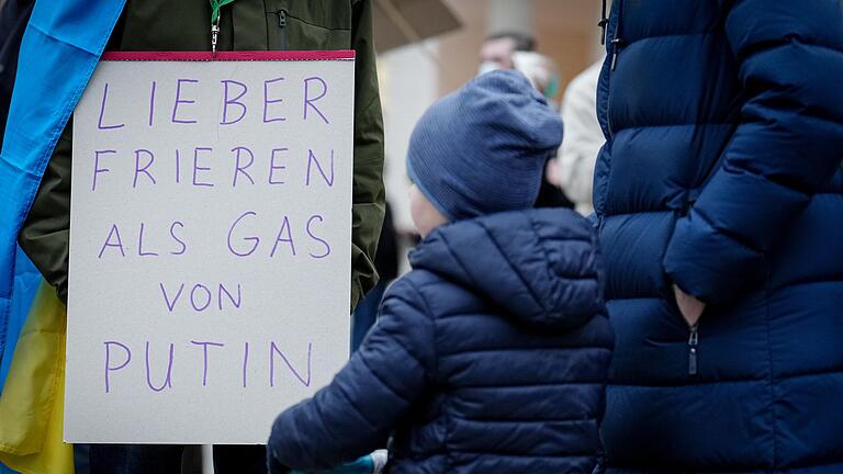 Ein Teilnehmerin einer Berliner Demonstration gegen den Krieg in der Ukraine zeigt ein Plakat mit der Aufschrift 'Lieber frieren als Gas von Putin' vor dem Brandenburger Tor. Ein Teilnehmerin einer Berliner Demonstration gegen den Krieg in der Ukraine zeigt ein Plakat mit der Aufschrift 'Lieber frieren als Gas von Putin' vor dem Brandenburger Tor.