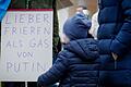 Ein Teilnehmerin einer Berliner Demonstration gegen den Krieg in der Ukraine zeigt ein Plakat mit der Aufschrift 'Lieber frieren als Gas von Putin' vor dem Brandenburger Tor.