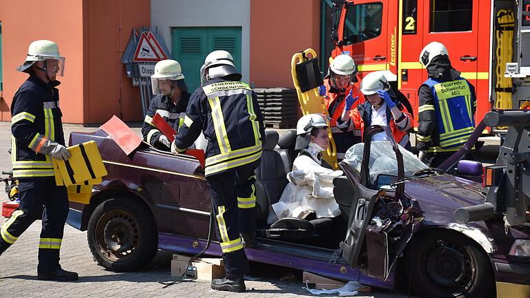 Es knackt und knirscht und splittert, bis eine eingeklemmte Person aus dem Fahrzeug befreit und zum Beispiel das Autodach mit der Rettungsschere abgeklemmt ist. Selbst die Unfall-Mimen wurden mit Tüchern und wie hier mit einem Feuerwehrhelm abgesichert.