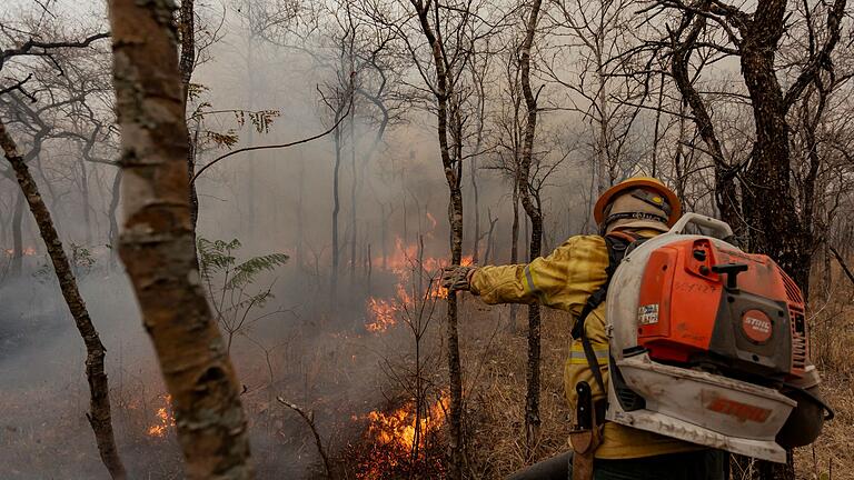 Indigene Feuerwehrleute kämpfen in Brasilien um ihr Territorium - Flammen fressen sich durch die trockene Landschaft. Indigene Feuerwehrleute kämpfen in Brasilien um ihr Territorium - Flammen fressen sich durch die trockene Landschaft.