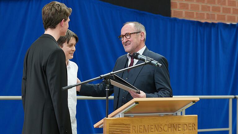 Klaus Gerlach bedankt sich bei den Schülervertretern (von links) Fabian Folk und Justus Schuster für deren Rede und für die Überreichung eines Abschiedsgeschenks. Klaus Gerlach bedankt sich bei den Schülervertretern (von links) Fabian Folk und Justus Schuster für deren Rede und für die Überreichung eines Abschiedsgeschenks.