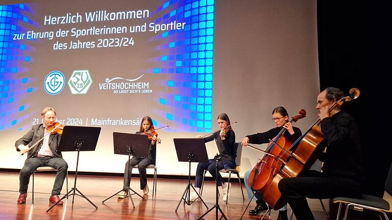 Für den festlichen Rahmen der Sportlerehrung sorgte zwischen den Ehrungsblöcken der Gemeinde und der beiden Vereine das Streicherensemble der Sing- und Musikschule Veitshöchheim mit drei Schülerinnen und den Lehrkräften Rainer Nürnberger (links) und Andreas Franzky (rechts) u.a. mit Elvis Presleys Liebessong 'Can't help falling in love'.