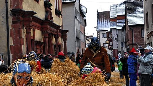 Alter Brauch: Die „Strohbären“ verteilen das Stroh, in das sie gewickelt sind auf dem Weg zum Rathaus auf den Straßen. Alter Brauch: Die „Strohbären“ verteilen das Stroh, in das sie gewickelt sind auf dem Weg zum Rathaus auf den Straßen.