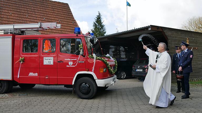 Pfarrer Michael Rompf segnet das Löschfahrzeug der Hilpertshausener Feuerwehr. Die Feuerwehrkameraden aus Veit haben es von der benachbarten Burggrumbacher Wehr übernommen und für ihre Zwecke umgerüstet.