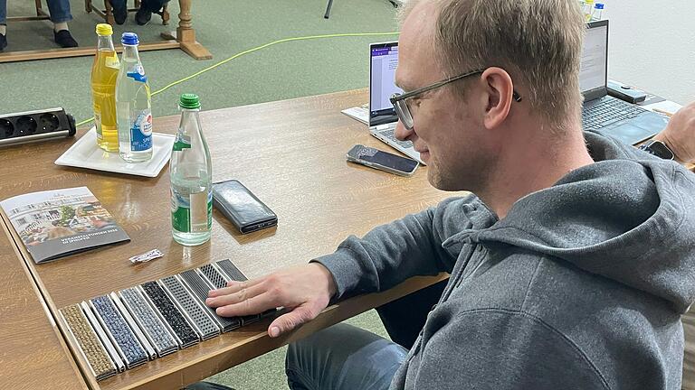Da strichen manche Gemeinderäte auch einmal über die Muster der Schmutzfänger, wie hier Stefan Düll. Der Gemeinderat hatte nämlich die Aufgabe, die passende Farbe auszuwählen.