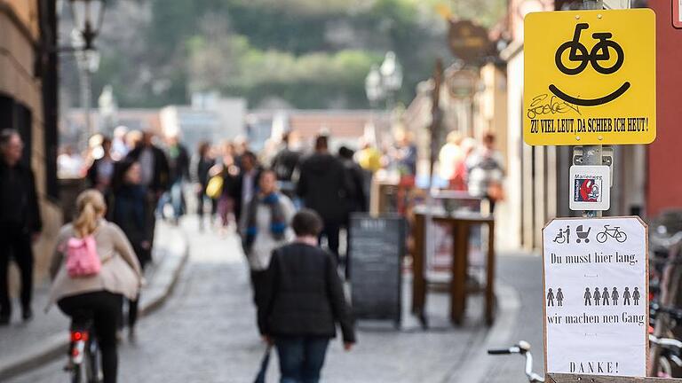 Radlerprotest: Zusätzlich zum offiziellen gelben Schild an der Alten Mainbrücke prangte am Montag darunter ein selbst gemachtes, weißes, darauf stand: &bdquo;Du musst hier lang, wir machen nen Gang&ldquo;.