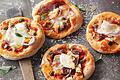 Vier kleine Pizzen kommen frisch aus dem Ofen (Symbolbild). Einiges verändert hat sich in der Gastronomie im Landkreis Kitzingen, auch neue Pizzabäcker gibt es.