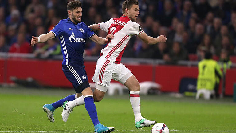 Zweikampf       -  Der Schalker Daniel Caligiuri (l) und Joel Veltman (r) von Ajax Amsterdam kämpfen um den Ball. Foto: Ina Fassbender