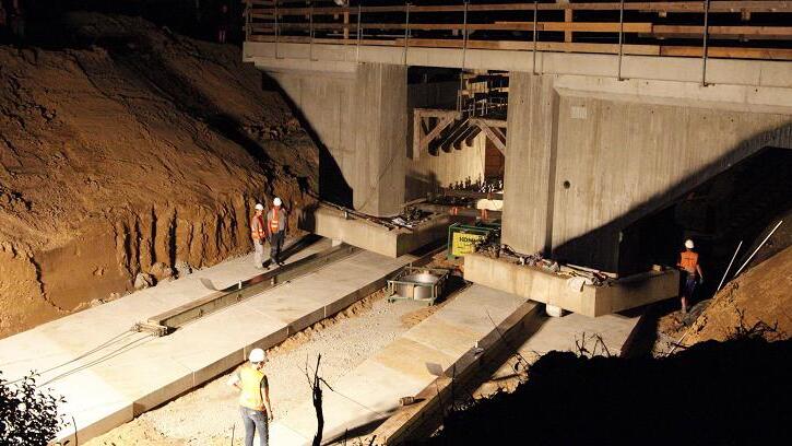 1000 Tonnen wiegt die neue Bahnbrücke bei Kilometer 2,6 an der Werntalbahn zwischen Waigolshausen und Gemünden nahe Zeuzleben. Sie wurde Mittwochnacht mit Hydraulikpressen dreieinhalb Stunden lang an ihren Platz gezogen, übers Wochenende wird das Gleis eingebaut. Insgesamt wurden an der Strecke, die hauptsächlich für Güterverkehr genutzt wird, sechs Brücken saniert. 1000 Tonnen wiegt die neue Bahnbrücke bei Kilometer 2,6 an der Werntalbahn zwischen Waigolshausen und Gemünden nahe Zeuzleben. Sie wurde Mittwochnacht mit Hydraulikpressen dreieinhalb Stunden lang an ihren Platz gezogen, übers Wochenende wird das Gleis eingebaut. Insgesamt wurden an der Strecke, die hauptsächlich für Güterverkehr genutzt wird, sechs Brücken saniert.