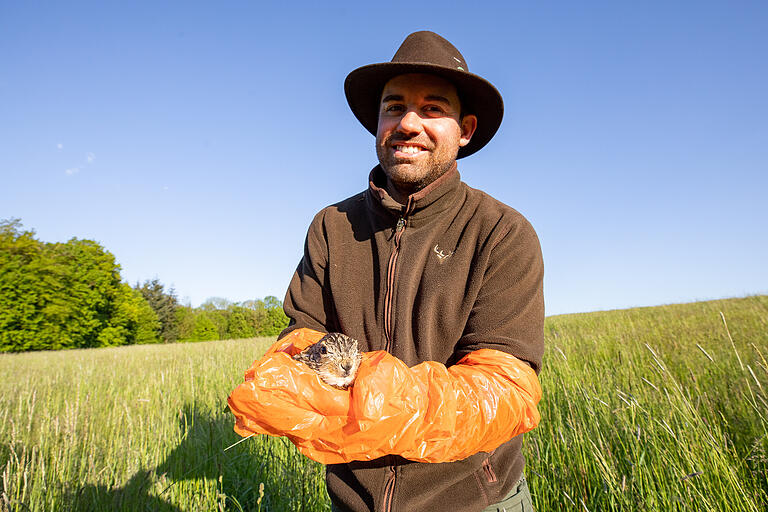 Achim Hoffmann mit einem kleinen Feldhasen in der Hand.