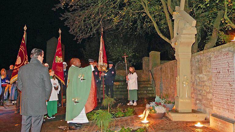 Father Dunstan Asiimwe segnet den neuen Standort des Kreuzschleppers und der beiden Gedenktafeln an die Gefallenen der zwei Weltkriege. Father Dunstan Asiimwe segnet den neuen Standort des Kreuzschleppers und der beiden Gedenktafeln an die Gefallenen der zwei Weltkriege.