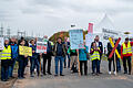Vertreterinnen und Vertreter der Bürgerinitiativen stehen mit Protestschildern gegen den Stromtrassenbau bei der Kundgebung am Felsenhof bei Bergrheinfeld.