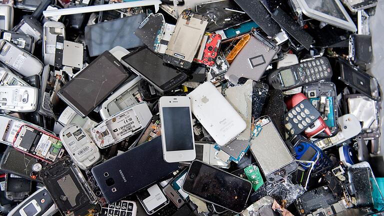 Elektroschrott - Alte Handys und Smartphones liegen in einem Container, ehe sie geschreddert werden. Davor sollten wertvolle Metalle und seltene Erden noch recycelt werden. Elektroschrott - Alte Handys und Smartphones liegen in einem Container, ehe sie geschreddert werden. Davor sollten wertvolle Metalle und seltene Erden noch recycelt werden.