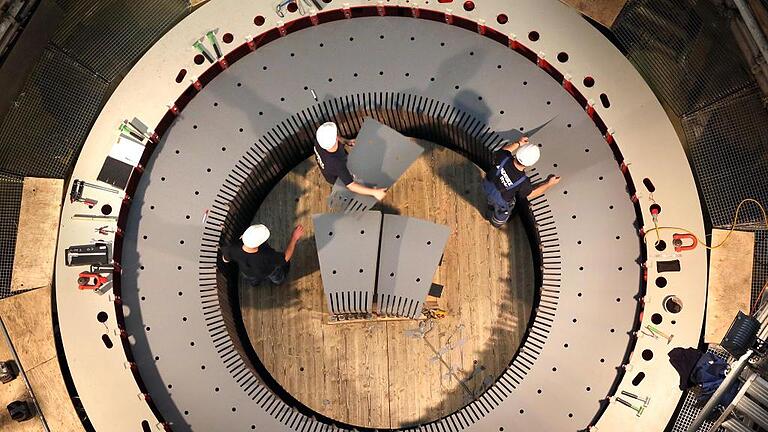 Blick in die Tiefe: Einer der beiden Generatoren bekommt neue Blechpakete. Jeweils drei Arbeiter legen zigtausende dünne Platten von Hand im Schichtbetrieb auf. Blick in die Tiefe: Einer der beiden Generatoren bekommt neue Blechpakete. Jeweils drei Arbeiter legen zigtausende dünne Platten von Hand im Schichtbetrieb auf.