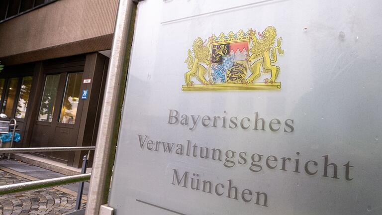 Bayerisches Verwaltungsgericht       -  Ein Schild mit dem bayerischen Wappen und der Aufschrift „Bayerisches Verwaltungsgericht München“ hängt am Eingang des Gebäudes.