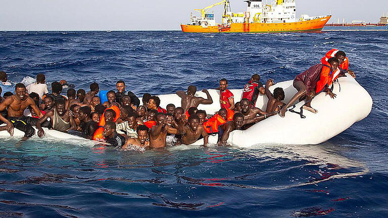 Flüchtlingskatastrophe       -  Kurz vor dem Sinken: Flüchtlinge auf einem havarierten Schlauchboot auf offener See vor der italienischen Insel Lampedusa. Foto: Ong Sos Mediterranee