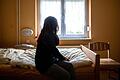 Eine Frau sitzt in einem Frauenhaus auf einem Bett.&nbsp;