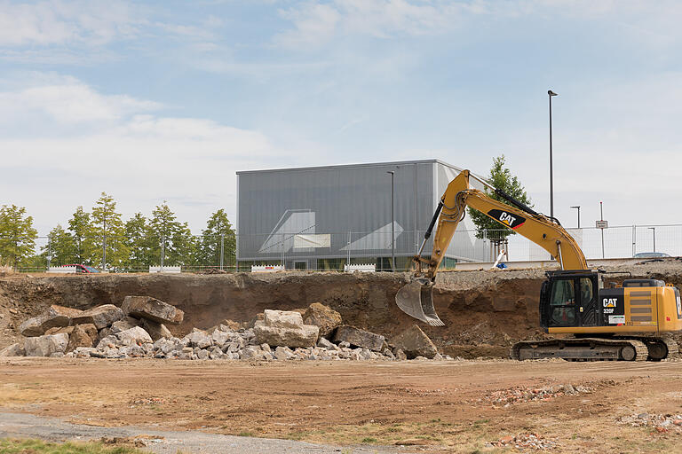 An vielen Stellen wird noch gebaut. Der Bagger gräbt auf der Höhe der alten Tankstelle, im Hintergrund ist der sogenannte 'Cube', des Zentrums für digitale Innovationen, zu sehen.