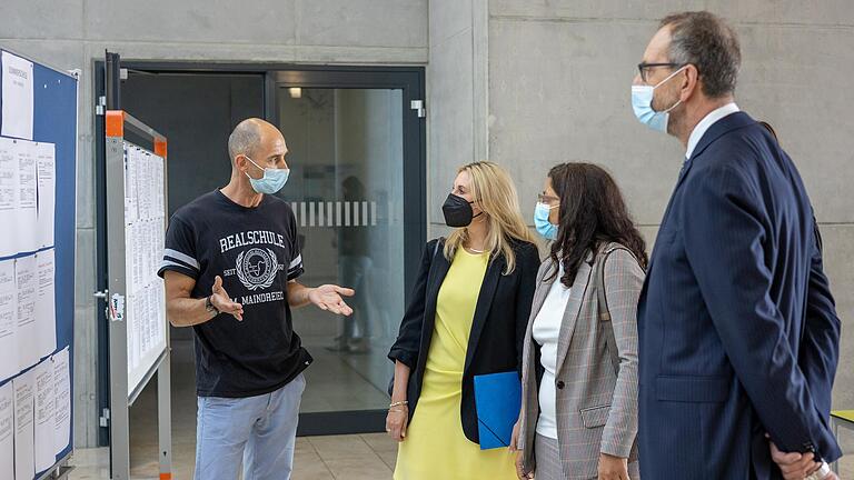 Anhand von Wochenplänen erklärt Beratungsrektor Martin Schmitt,&nbsp; wie die Realschule Ochsenfurt das Konzept der Sommerschule umgesetzt hat (v.l.: Anna Stolz, stellvertretende Landrätin Christine Haupt-Kreutzer, Ministerialbeauftragter für die Realschulen in Unterfranken&nbsp;Karlheinz Lamprecht).