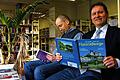 Lesen und Lächeln: Bürgermeister Georg Ondrasch und Bibliotheksleiter Joachim Hellmann in der Stadtbibliothek Gemünden.