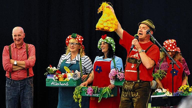 Der Preis ist heiß: Der immer gut gelaunte Moderator Fredi Breunig hät die Kartoffeln hoch, die die zweitplatzierten, das Damen-Quartett „Körperwelten“ neben dem Pokal mit nach Hause nahmen. Links im Bild Konni Albert aus Hammelburg. Der Preis ist heiß: Der immer gut gelaunte Moderator Fredi Breunig hät die Kartoffeln hoch, die die zweitplatzierten, das Damen-Quartett „Körperwelten“ neben dem Pokal mit nach Hause nahmen. Links im Bild Konni Albert aus Hammelburg.