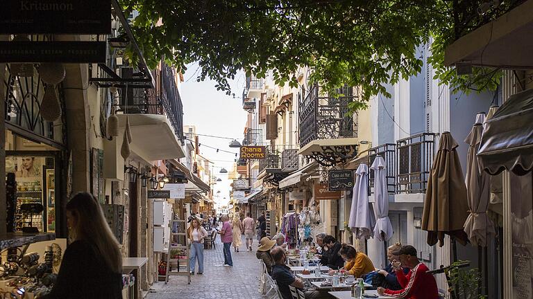 kreta griechenland insel touristen.jpg       -  Touristen frühstücken in einer Gasse in der Altstadt von Chania auf Kreta. Die beliebte Urlaubsinsel liegt südlich vom griechischen Festland im Mittelmeer.