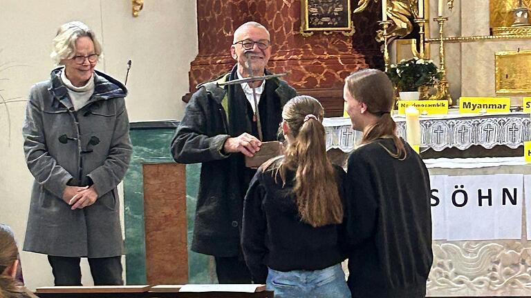 Schülerinnen der St.-Ursula-Schule Würzburg übergeben in der Antoniterkirche Pfarrer Jürgen Reichel und Pfarrerin Margarete Allolio vom Nagelkreuzzentrum Würzburg das Wandernagelkreuz und die Versöhnungsstatue. Schülerinnen der St.-Ursula-Schule Würzburg übergeben in der Antoniterkirche Pfarrer Jürgen Reichel und Pfarrerin Margarete Allolio vom Nagelkreuzzentrum Würzburg das Wandernagelkreuz und die Versöhnungsstatue.