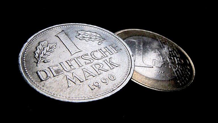 Euro und D-Mark - Eine Deutsche Mark (D-Mark, l) und eine Ein-Euro-Münze. Euro und D-Mark - Eine Deutsche Mark (D-Mark, l) und eine Ein-Euro-Münze.