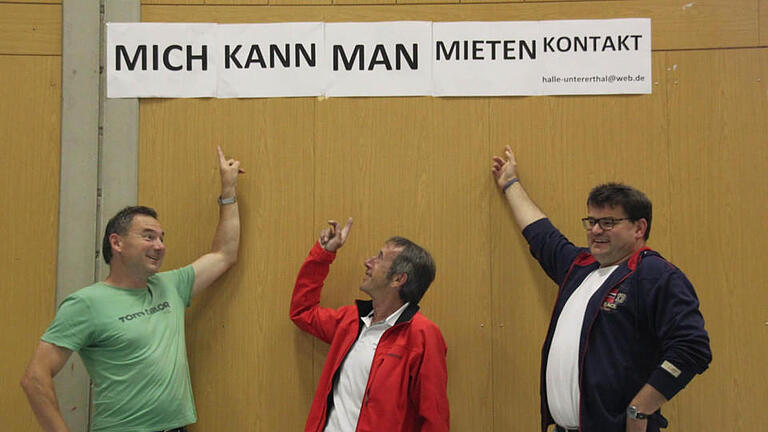 Mit einem Schild in der Erthalhalle machen die Verantwortlichen der Sporthallengesellschaft (von links: 2. Vorsitzender Bernd Hüfner, Vorsitzender Amand Kuchenbrod und Kassier Peter May) darauf aufmerksam, dass die Halle von jedermann angemietet werden kann. Foto: Kerstin Väth       -  Mit einem Schild in der Erthalhalle machen die Verantwortlichen der Sporthallengesellschaft (von links: 2. Vorsitzender Bernd Hüfner, Vorsitzender Amand Kuchenbrod und Kassier Peter May) darauf aufmerksam, dass die Halle von jedermann angemietet werden kann. Foto: Kerstin Väth