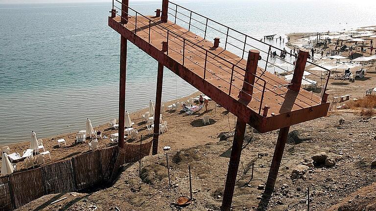 Totes Meer       -  Ein älterer Steg an der Küste des Toten Meeres in Israel zeigt, wie drastisch der Meeresspiegel in den vergangenen Jahrzehnten abgesunken ist. Nach Angaben von Forschern sind dem See in den vergangenen 30 Jahren 14 Kubikkilometer Wasser verloren gegangen.