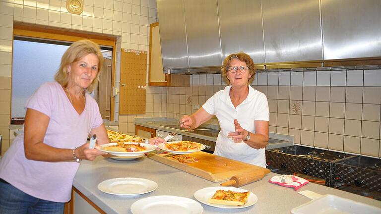 Heute gibt es leckere Pizza und Irmgard Reß (rechts)holt die Bleche aus dem Ofen. Die Stücke werden von Isolde Herold ofenfrisch serviert. Heute gibt es leckere Pizza und Irmgard Reß (rechts)holt die Bleche aus dem Ofen. Die Stücke werden von Isolde Herold ofenfrisch serviert.