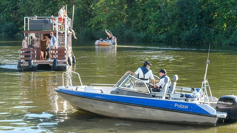 Ein Partyboot (links) und ein Grillboot (Mitte hinten) dümpeln auf dem Main in der Nähe des Würzburger Stadtstrands. Zu den Aufgaben der Wasserschutzpolizei gehört es, die Fahrtüchtigkeit der Bootsführer zu überprüfen.&nbsp;