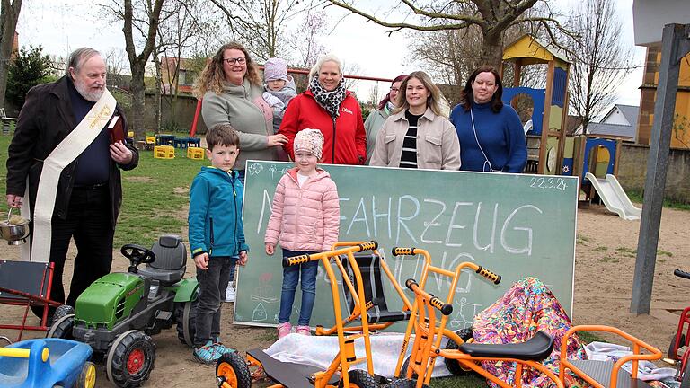 Die Kleinen vom Kindergarten St. Josef in Stadtschwarzach können sich über vier Spielfahrzeuge freuen, die der Elternbeirat spendiert hatte. Diakon Rudolf Reuter (links) segnete die Treträder.