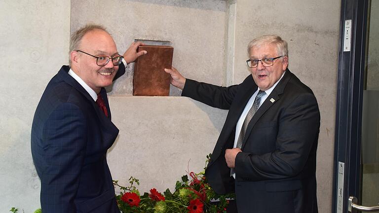 Schulleiter Wolfram Schröttel (links) und Landrat Helmut Weiß versenkten die Zeitkapsel in der Wand.