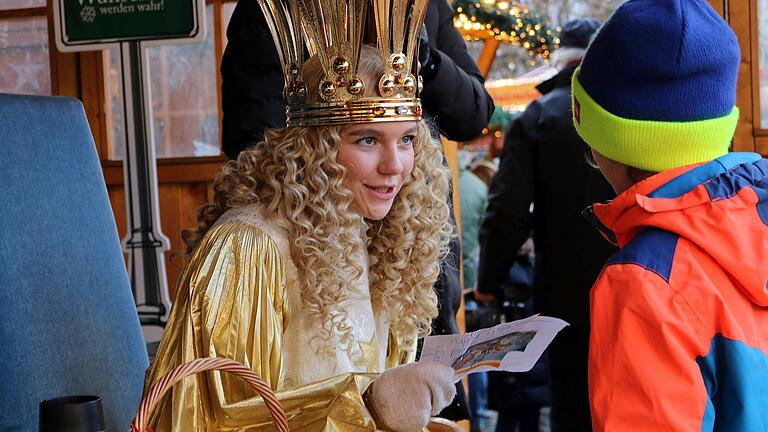 Das Nürnberger Christkind nahm auf der Bühne auf dem Schweinfurter Weihnachtsmarkt die Wunschzettel der Kinder entgegen. Als Belohnung gab es schonmal eine Schokolade vom Christkind. Das Nürnberger Christkind nahm auf der Bühne auf dem Schweinfurter Weihnachtsmarkt die Wunschzettel der Kinder entgegen. Als Belohnung gab es schonmal eine Schokolade vom Christkind.