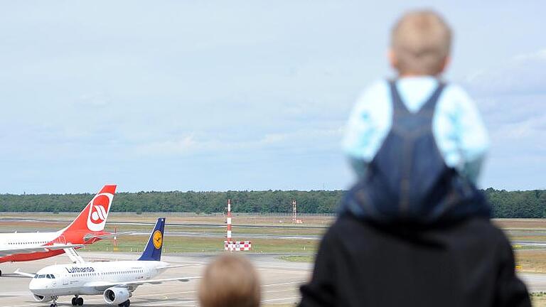 Kleinkinder fliegen sicher in einem Autokindersitz. Foto: Britta Pedersen       -  Was müssen Eltern beachten, damit sie sicher und entspannt mit kleinen Kindern fliegen können?