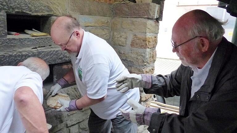 Heiß geht es her, wenn Wolfgang Denner und Klaus Seubert die Brotlaibe aus dem Backofen holen und an die anderen Helfer, hier Dieter Hensel, weiterreichen. Heiß geht es her, wenn Wolfgang Denner und Klaus Seubert die Brotlaibe aus dem Backofen holen und an die anderen Helfer, hier Dieter Hensel, weiterreichen.