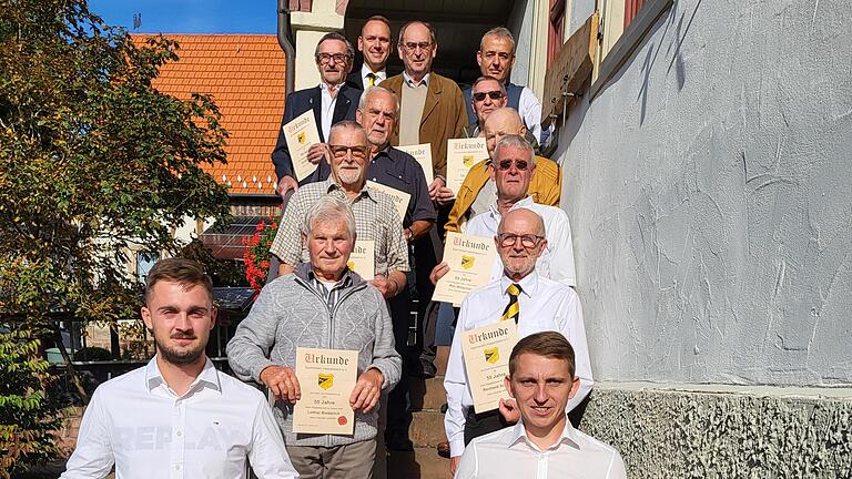 Ganz hinten Bürgermeister Mario Götz, davor (von hinten nach vorn, von links) Günther Straub, Horst Schäfer, Michael Schmitt, Rainer Huppman, Horst Henz, Horst Dienelt, Manfred Reuter und Max Wütscher,, Lothar Bieberich und rechts Reinhold Schmitt...       -  Ganz hinten Bürgermeister Mario Götz, davor (von hinten nach vorn, von links) Günther Straub, Horst Schäfer, Michael Schmitt, Rainer Huppman, Horst Henz, Horst Dienelt, Manfred Reuter und Max Wütscher,, Lothar Bieberich und rechts Reinhold Schmitt. Den Schal halten  Tim Hofmann (links, Fußballer) und rechts Domink Metz (Vorstand).