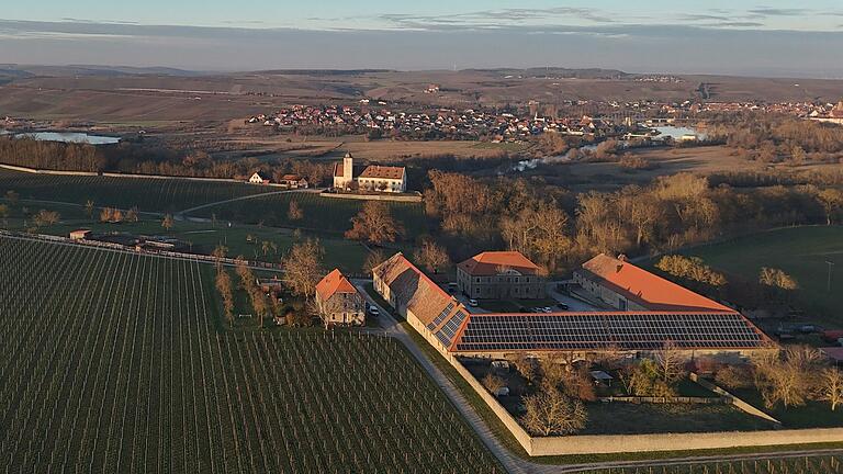 Die Hallburg von oben mit Volkach und der Mainschleife im Hintergrund. Gut zu sehen ist die Gutsanlage (vorne rechts) und dahinter das Schloss Hallburg mit der Vinothek im Jägerhaus llinks daneben. Die Hallburg von oben mit Volkach und der Mainschleife im Hintergrund. Gut zu sehen ist die Gutsanlage (vorne rechts) und dahinter das Schloss Hallburg mit der Vinothek im Jägerhaus llinks daneben.