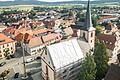 Das Dach der Hofheimer Stadtpfarrkirche St. Johannes der Täufer wird aktuell saniert. Mit einer weißen Plane ist ein Teil des Dachs abgedeckt.