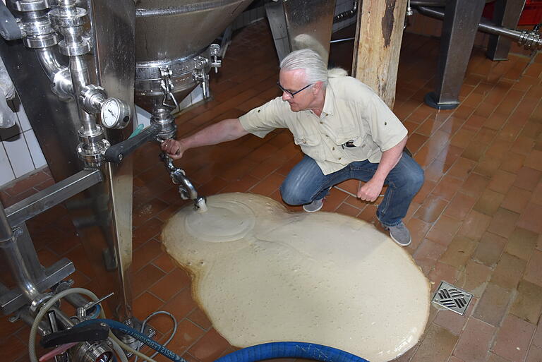 Nach dem 'Hefe-Abschießen' aus den Tanks, muss auch der Brauerei-Gehilfe seine Vielseitigkeit unter Beweis stellen. Gleich kommt der Wasserschlauch zum Einsatz, um den schönen Schaum – eigentlich schade drum– in den Abfluss zu spülen.