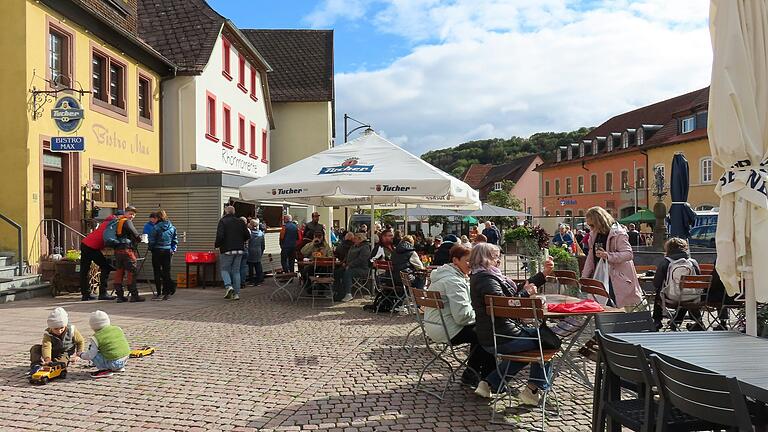 Der Genuss- und Kunsthandwerkermarkt in Bischofsheim lockte trotz kühler Temperaturen viele Besucher an.
In den warmen Strahlen der Nachmittagssonne suchten sich viele Besucherinnen und Besucher des Marktes einen Platz im Freien.