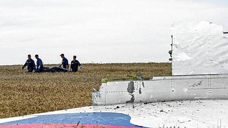 Final report on downing of MH17 to be released       -  epa04975641 (FILE) People carry a stretcher with a bodybag past the debris of a Boeing 777 Malaysia Airlines flight MH17 airplane, which crashed during flying over the eastern Ukraine region, at the crash site near Donetsk, Ukraine, 19 July 2014. The Dutch Safety Board, on 13 October 2015, will report the results of its investigation into the downing of Malaysia Airlines flight MH17 over Ukraine which killed all 298 people on board. The report is to answer whether the Boeing jet was struck by a Russia-made ground-to-air Buk missile. The aeroplane was en route from Amsterdam to Kuala Lumpur at the time of the July 17, 2014, crash. The Netherlands has taken the lead in the investigation, since most of the dead were Dutch nationals. EPA/ANASTASIA VLASOVA +++(c) dpa - Bildfunk+++