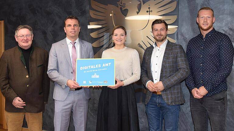 Die Auszeichnung 'Digitales Amt' überreichte in Form eines Schildes Bayerns Digitalministerin Judith Gerlach (Mitte) an Bürgermeister Oliver Schulze (Zweiter von links). Im Sennfelder Rathaus dabei waren (von links) Landtagsabgeordneter Gerhard Eck, Geschäftsleiter Thomas Wagenhäuser und IT-Betreuer Niklas Reuß.