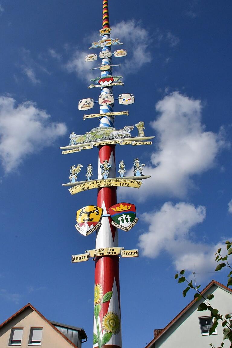 Der Zunftbaum am Dorfplatz von Sulzfeld. Hier sind die Handwerksbetriebe und ihre Zunftzeichen und Wappen zu sehen, die es in Sulzfeld einst gab und heute noch gibt. Der Zunftbaum am Dorfplatz von Sulzfeld. Hier sind die Handwerksbetriebe und ihre Zunftzeichen und Wappen zu sehen, die es in Sulzfeld einst gab und heute noch gibt.