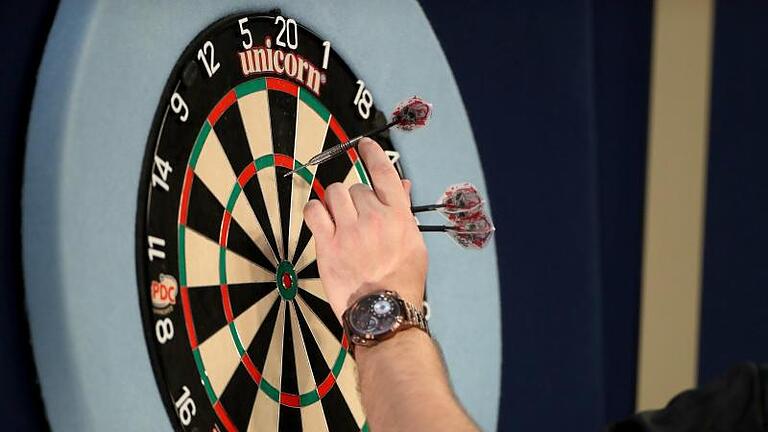 Ein Spieler holt bei der WM seine Darts vom Board. Foto: Bradley Collyer/PA Wire/dpa       -  Ein Spieler holt bei der WM seine Darts vom Board.